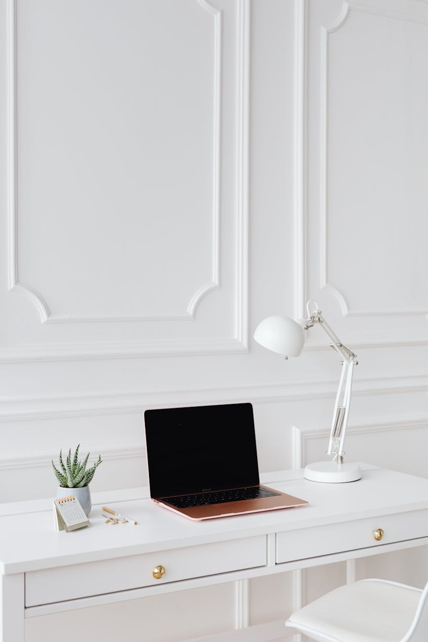 a laptop and desk lamp on the table